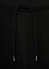 Pantalón negro de piqué con cintura elástica, tiro alto, diseño jogger, bolsillos laterales y costuras decorativas.