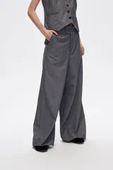 Pantalón gris de poliéster, corte ancho y tiro alto, con bolsillos laterales.