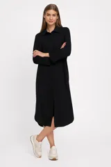 Túnica midi color beige de lino, corte holgado, manga larga, cuello camisero y cierre frontal con botones.