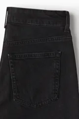 Jean tobillero de denim negro lavado, tiro alto, con cinco bolsillos y cierre de botón. Corte ajustado en cadera y muslo, con pierna recta y levemente ceñida en el bajo.