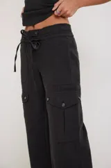 Pantalón cargo color crema, de corte recto y tiro alto, con bolsillos laterales con solapa y ajuste con cordón en la cintura.