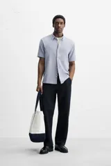 Camisa celeste de corte recto, manga corta y cuello solapa.