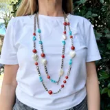 Collar largo con cadena plateada de eslabones y piedras de coral, turquesa y nácar. Incluye dijes en forma de corazón de nácar.