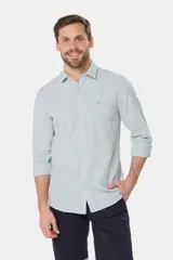 Camisa de manga larga, color celeste con finas rayas blancas, confeccionada en una mezcla de lino y algodón. Presenta un corte slim fit y no tiene bolsillo.