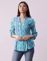 Blusa de gasa estampada, marca Ruby Rd. Cuello a la base, escote en V y abertura central con botones. Delantera con plisados. Largo de manga regulable con presilla y botón.