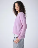 Sweater de cashmere color lila con cuello en V, corte oversize, mangas largas, hombros caídos y terminaciones acanaladas.
