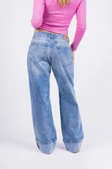 Pantalón de jean celeste de corte ancho con dobladillo en el ruedo.