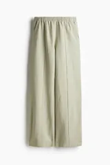 Pantalón de lino color verde claro, de tiro alto con cintura elástica, bolsillos al bies y bolsillos atrás insertados. Piernas rectas con pliegue cosido adelante.