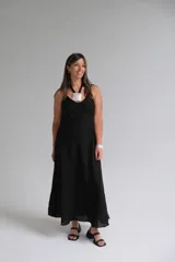 Vestido largo negro de breteles finos, corte recto y falda amplia.