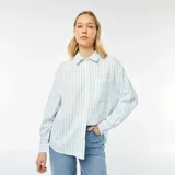 Camisa celeste y blanca a rayas verticales, de corte holgado, manga larga y bolsillo de parche en el pecho.