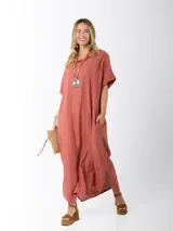 Vestido largo color ladrillo, de lino, corte amplio, mangas cortas, cuello bote y bolsillos laterales.