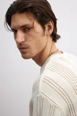 Buzo color crema en punto pointelle de mezcla de algodón, lino y viscosa. Modelo de hombros caídos con cuello redondo y bajo recto. Borde enrollado en cuello, puños y bajo.