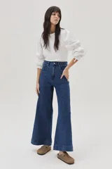 Blusa blanca de mangas largas abullonadas con puños elásticos y lazos.