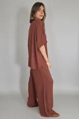 Conjunto de lino color marrón chocolate, compuesto por un remerón de mangas cortas con cuello en V y un pantalón palazzo de tiro alto con cintura elastizada y bolsillos laterales.