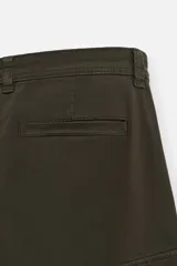 Pantalón cargo color verde oscuro, de corte relaxed fit, con bolsillos laterales con solapa y bolsillos traseros de vivo.