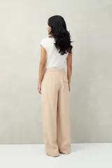 Pantalón sastrero ancho color crema con finas rayas verticales, de cintura alta con pinzas.