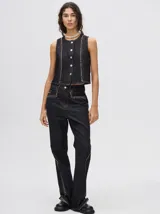 Pantalón de jean azul de tiro alto y corte oxford con apliques metálicos en bolsillos y laterales.