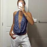 Top con escote halter y espalda descubierta, confeccionado en tela con lentejuelas azules.