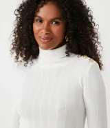 Blusa de tejido de punto acanalado color blanco, de manga larga y corte ajustado. Presenta cuello alto y detalles de botones dorados en los hombros.