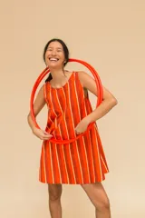 Vestido corto a rayas verticales en tonos marrón, negro y naranja. De corte recto, sin mangas y con cuello redondo. Confeccionado en algodón.