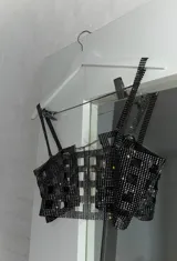 Top plateado con diseño de red con aberturas geométricas y tirantes finos.
