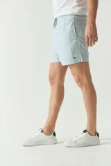 Short de baño con cintura elástica y cordón ajustable, con dos bolsillos laterales y uno trasero. Diseño a rayas horizontales en tonos de azul.