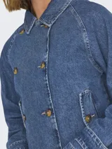 Chaqueta corta de jean azul con cuello clásico, cierre abotonado, bolsillos frontales y mangas largas con puños anchos.