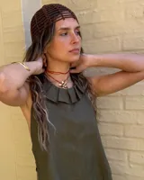 Collar artesanal con dije de flor plateada, realizado con hilo de seda natural teñido a mano.