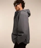 Campera gris con capucha, cuello alto, mangas largas y bolsillos con solapa y botones. Cierre frontal oculto. Marca Request, colección Primavera/Verano 2024.