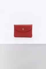 Monedero pequeño de cuero color rojo ladrillo, con cierre de broche metálico dorado.