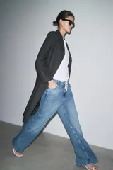 Pantalón de jean de tiro medio, pierna ancha y largo hasta el tobillo. Cintura con trabillas ajustable con cordones a contraste. Cinco bolsillos. Efecto lavado. Cierre frontal con cremallera y botón.