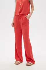 Pantalón de viscosa color beige, de corte ancho y tiro alto, con bolsillos laterales.