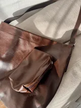 Bolso shopper color chocolate de eco-cuero, con correa regulable, cierre magnético y neceser removible con cierre.