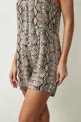 Mono corto color crudo, con breteles finos, escote en V y cierre frontal con botones.