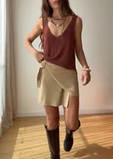 Minifalda cruzada color beige de tejido de punto con hebilla de madera. Tejido con hilado italiano de alta calidad con lurex y viscosa.