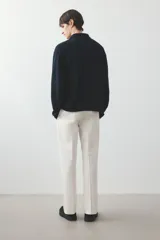 Pantalón de vestir color crema, de corte recto, con bolsillos laterales y traseros. Se ajusta a la cintura con botón.