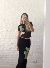 Top negro de microtul con estampado de orquídeas verdes.