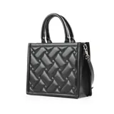 Bolso tote negro de cuero sintético acolchado con diseño rectangular. Tiene doble asa corta y correa larga regulable extraíble. El acceso es con cierre y cuenta con un bolsillo interno con cierre y dos abiertos.
