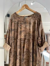 Vestido marrón con estampado animal print, de pana fina italiana, corte oversize, mangas 3/4 con puños doblados y largo irregular.