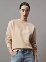 Buzo color beige de corte clásico con cuello redondo, puños y dobladillo acanalados. Presenta un logo institucional estampado en el pecho.