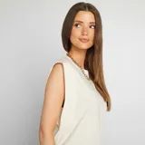 Camiseta blanca sin mangas con cuello redondo y hombreras marcadas.