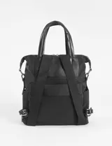 Mochila marrón de tela con detalles en cuero vegano negro, con doble asa de mano y correa de hombro ajustable.
