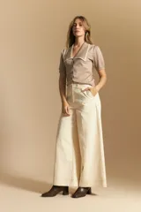 Pantalón ancho de tiro alto, color negro, con costuras contrastantes en blanco que definen los bolsillos y los bordes.