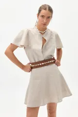 Camisa color natural de lino 100%, con cuello mao, corte holgado, botones de nácar y mangas cortas con vuelo en los hombros.