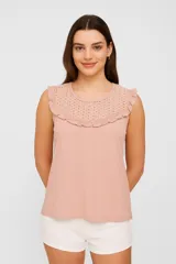Musculosa color rosa pálido sin mangas, con cuello redondo y detalle de broderie con volados en el canesú.