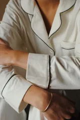 Conjunto de pijama de algodón gris con estampado geométrico blanco, compuesto por una camisa de manga larga con botones y un pantalón largo con elástico en la cintura.