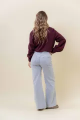 Jean de corte wide leg en color azul medio, con tiro medio, diseño de pierna amplia y fluida, y cinco bolsillos funcionales.