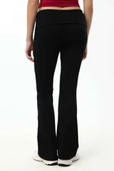 Calza de corte wide leg en color negro, confeccionada en algodón suave con cintura ancha ajustable.