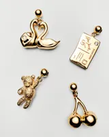 Dije charm dorado con forma de dos cisnes formando un corazón y una circonita blanca engarzada.