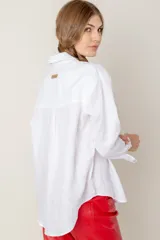 Camisa de lino color gris claro con bordado de monograma PEC en el bolsillo.